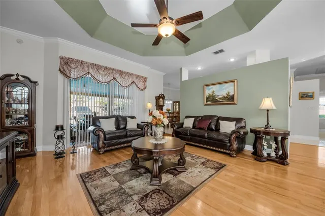 a dining room with furniture a rug a potted plant and a chandelier