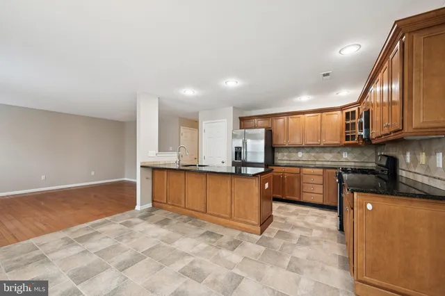 a large kitchen with stainless steel appliances granite countertop a granite counter tops and a stove