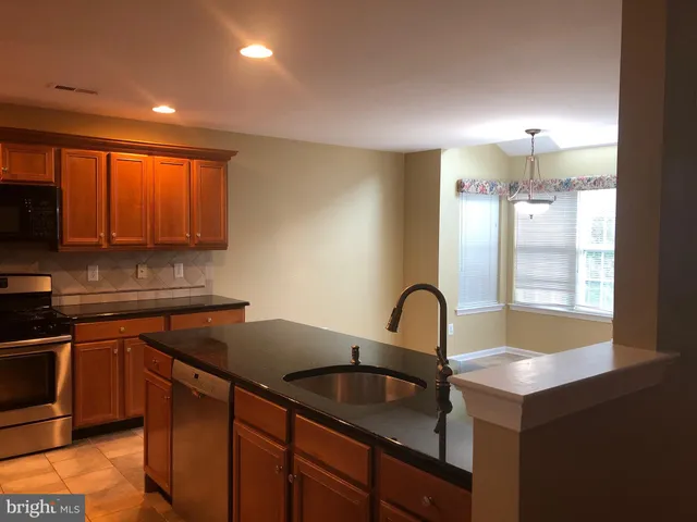 a kitchen with granite countertop a sink and cabinets