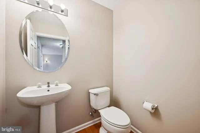 a bathroom with a toilet a sink and mirror