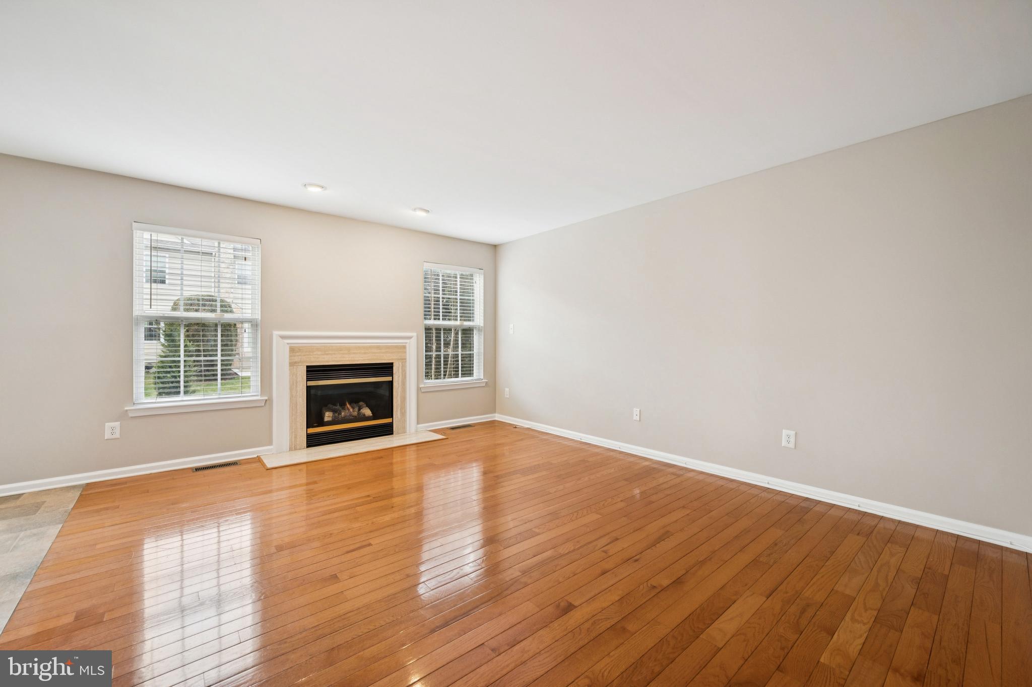 16 Hogan Way Moorestown, NJ 08057 - Photo 9 of 25 an empty room with wooden floor fireplace and windows