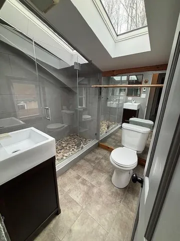 a bathroom with a toilet a sink and shower