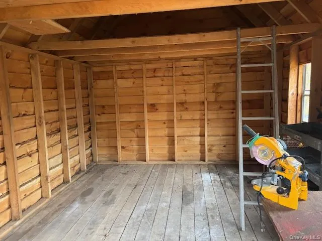 a view of empty room with wooden floor and windows