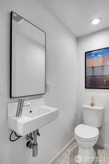a bathroom with a toilet sink and mirror
