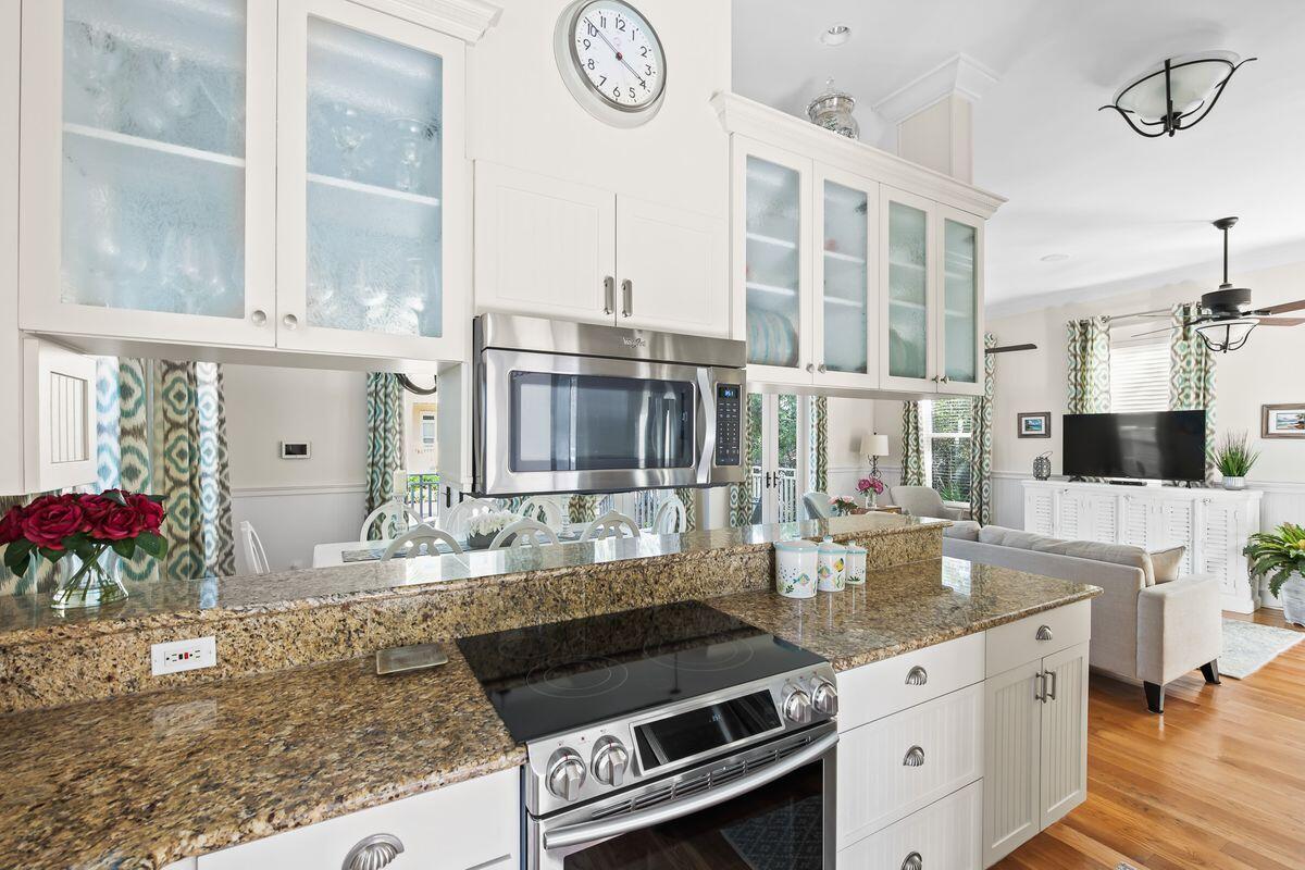 43 Sand Flea Drive Inlet Beach, FL 32461 - Photo 25 of 49 a kitchen with kitchen island granite countertop a stove and a white cabinets