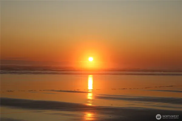 a front view of house with yard and trees in the background