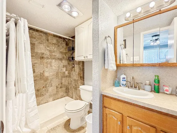 a bathroom with a sink a toilet and shower