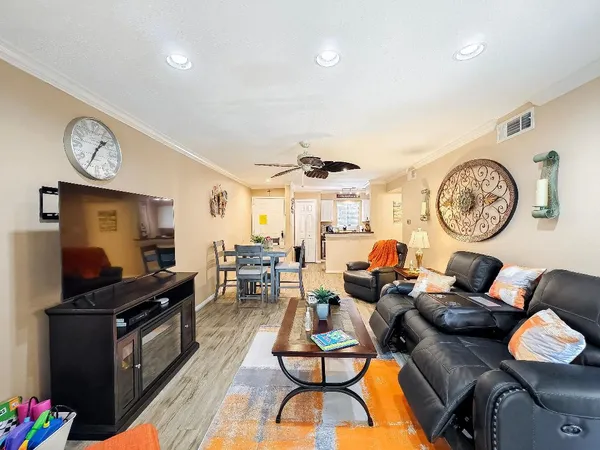 a living room with furniture a clock on wall and a window