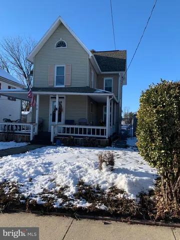 a front view of a house with a yard covered with snow