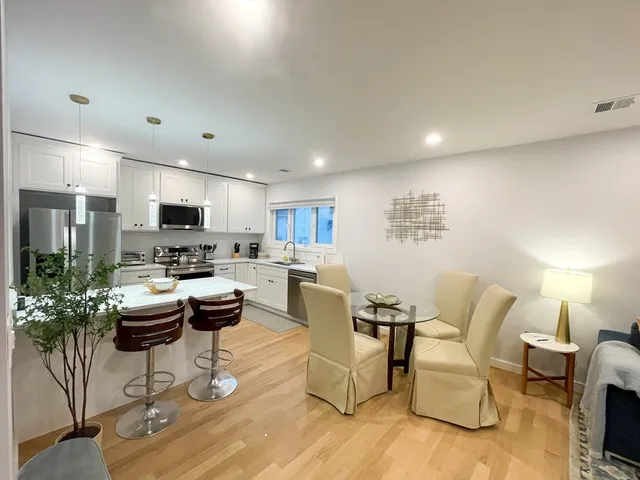 a living room with furniture and a view of kitchen