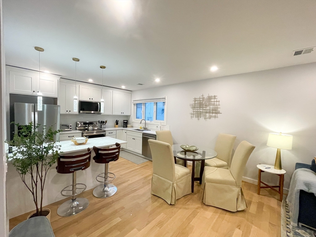 a living room with furniture and a view of kitchen