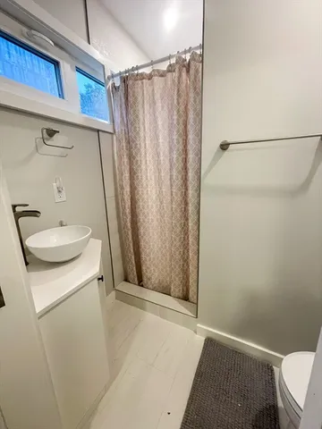 a bathroom with a sink a toilet and shower