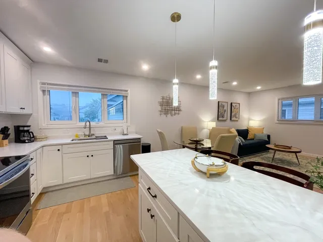 a large kitchen with stainless steel appliances kitchen island granite countertop a sink and cabinets