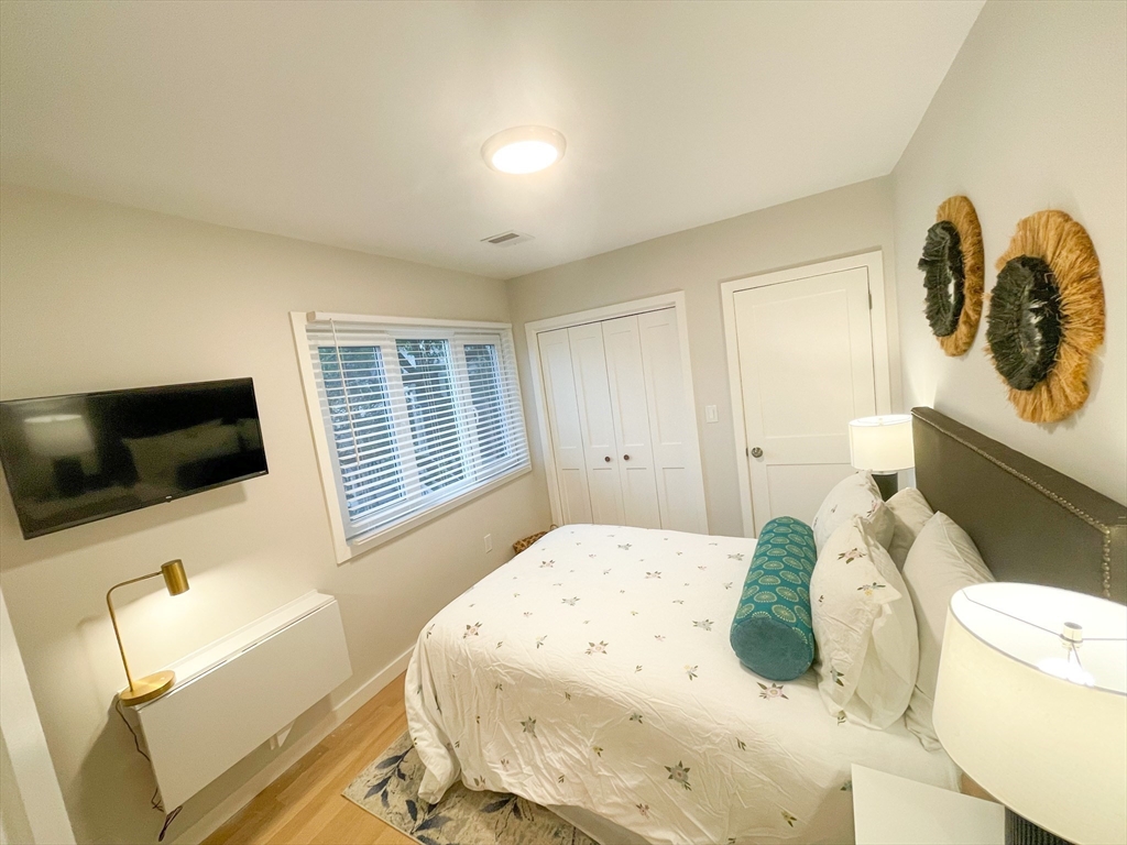 75 Thorndike Street, Unit 2FURNISHED Cambridge, MA 02141 - Photo 9 of 16 a bedroom with a bed and a flat screen tv