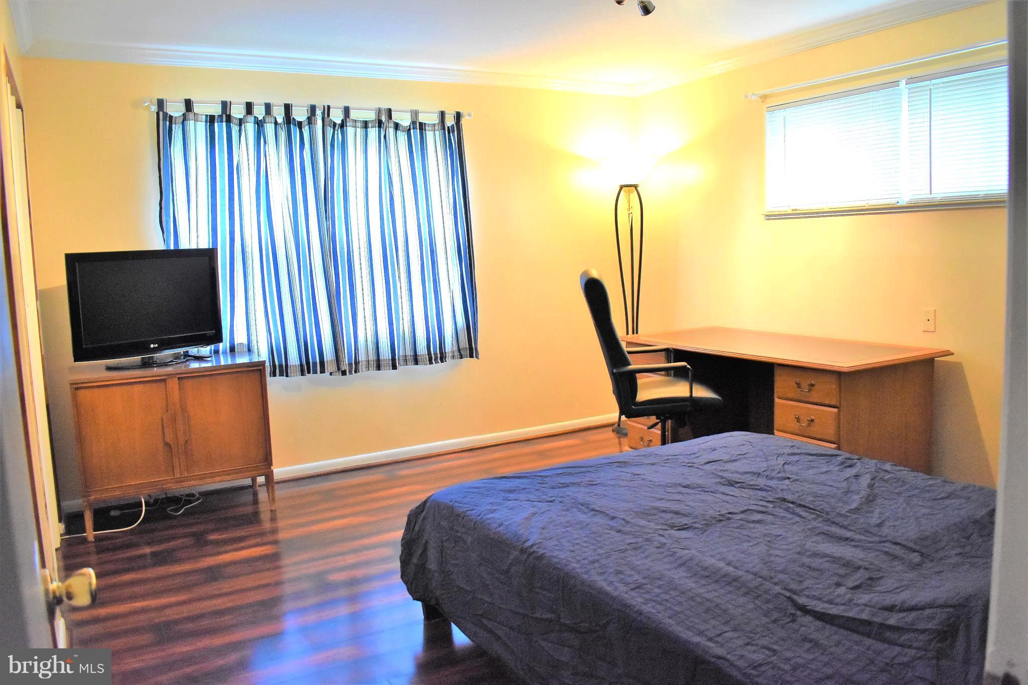 5810 Channing Road Springfield, VA 22150 - Photo 8 of 21 a bedroom with a bed window and flat screen tv