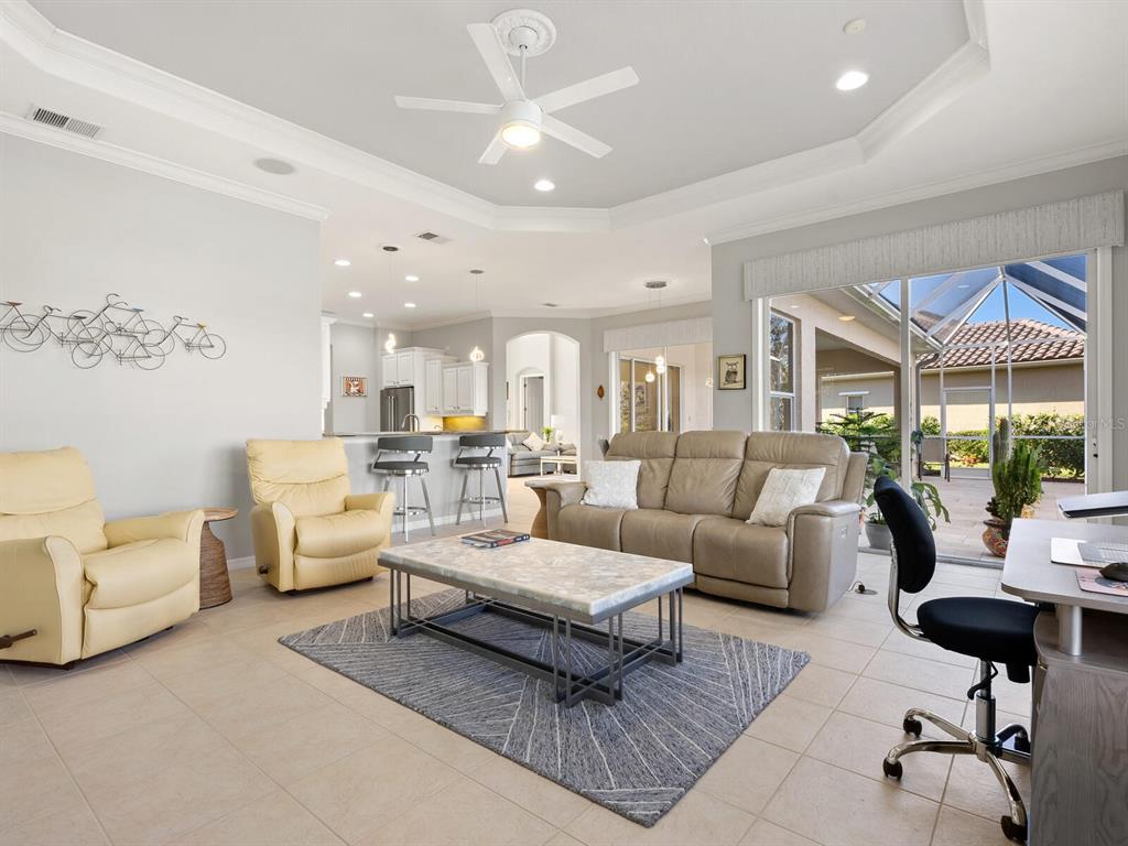 814 Adonis Place Venice, FL 34292 - Photo 14 of 38 a living room with furniture ceiling fan and a rug