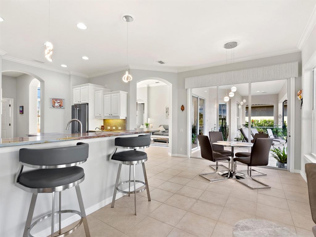 814 Adonis Place Venice, FL 34292 - Photo 15 of 38 a living room with furniture and a dining table with kitchen island