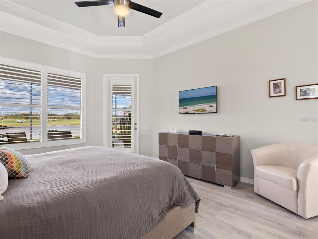 814 Adonis Place Venice, FL 34292 - Photo 22 of 38 a spacious bedroom with a bed and a couch