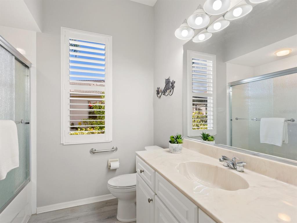 814 Adonis Place Venice, FL 34292 - Photo 27 of 38 a bathroom with a sink a toilet and a mirror