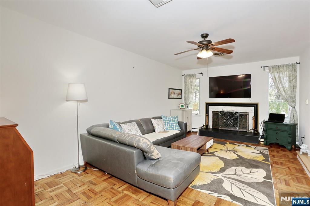 7 Tufts Court Paramus, NJ 07652 - Photo 11 of 50 a living room with furniture a fireplace and a flat screen tv