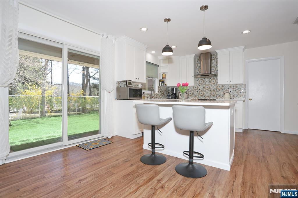 7 Tufts Court Paramus, NJ 07652 - Photo 13 of 50 a kitchen with stainless steel appliances kitchen island a large window and wooden floor