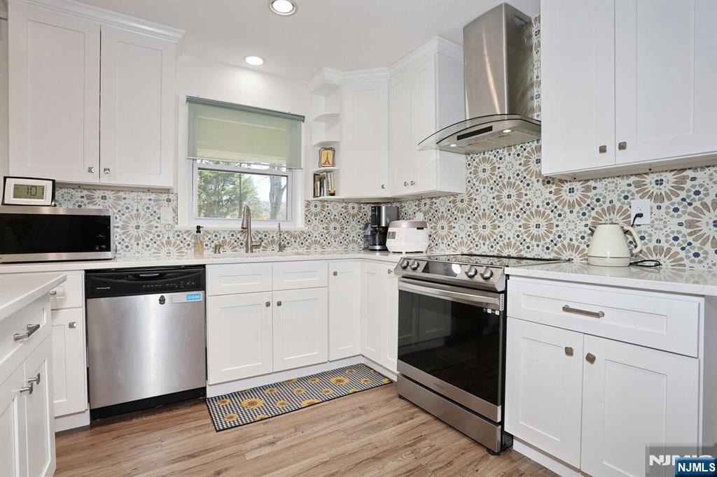 7 Tufts Court Paramus, NJ 07652 - Photo 14 of 50 a kitchen with stainless steel appliances white cabinets granite counter tops and a hard wood floors