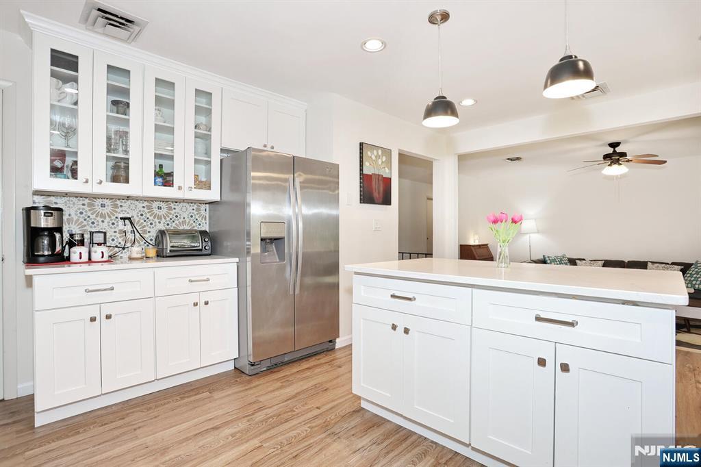 7 Tufts Court Paramus, NJ 07652 - Photo 16 of 50 a kitchen with stainless steel appliances granite countertop a refrigerator a sink dishwasher and white cabinets with wooden floor