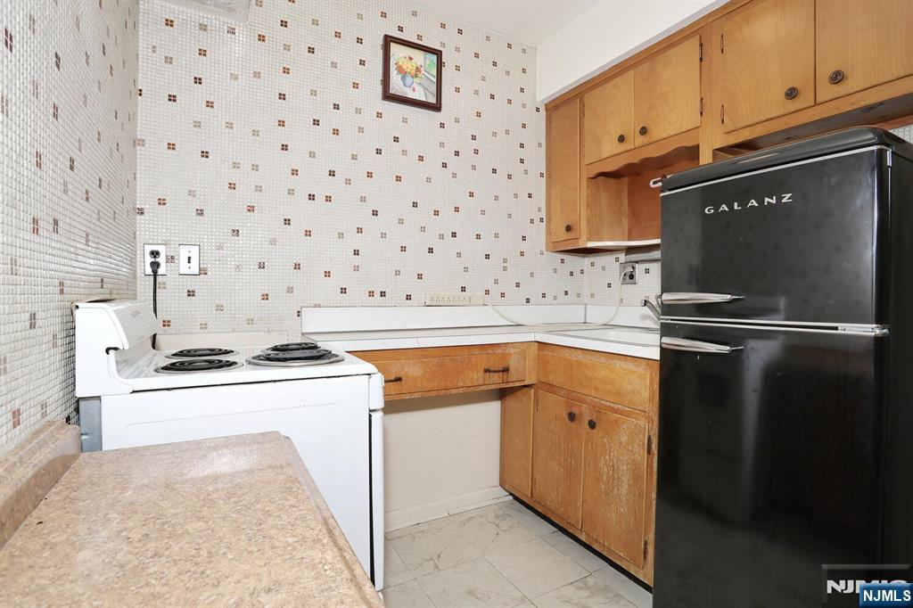 7 Tufts Court Paramus, NJ 07652 - Photo 30 of 50 a kitchen with granite countertop a sink stove and refrigerator