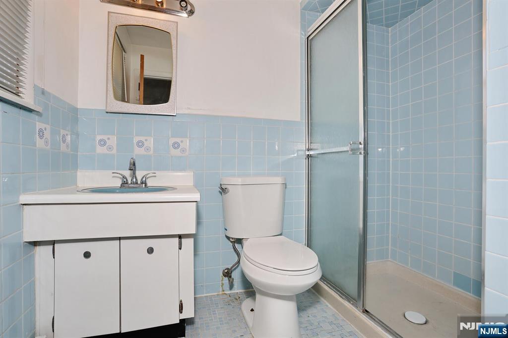 7 Tufts Court Paramus, NJ 07652 - Photo 32 of 50 a bathroom with a toilet a sink a mirror and vanity