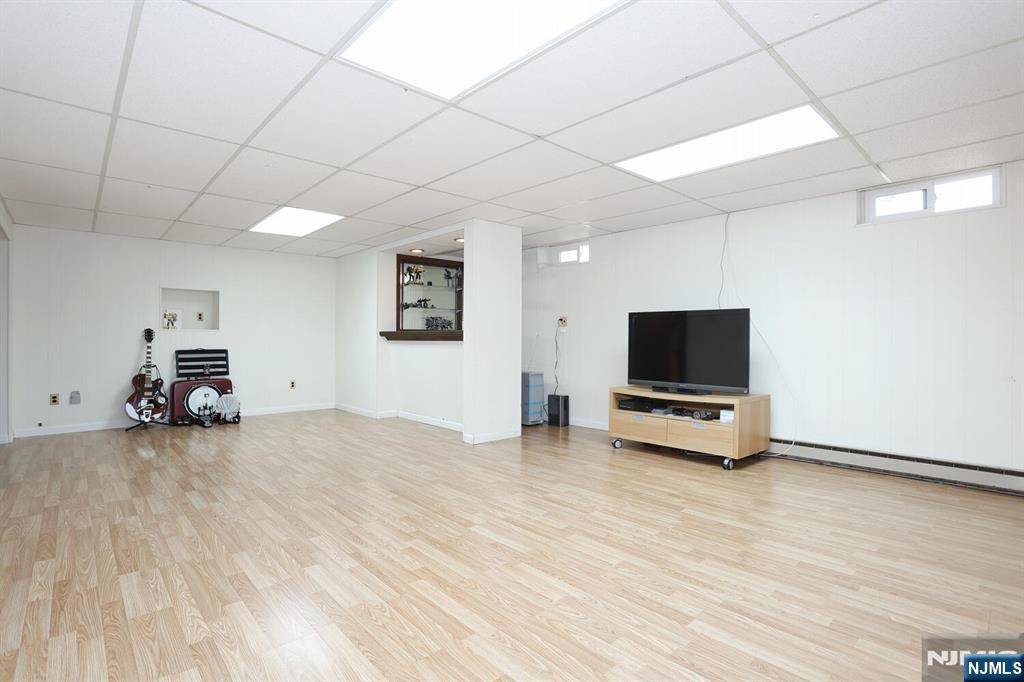 7 Tufts Court Paramus, NJ 07652 - Photo 39 of 50 a view of a livingroom with a flat screen tv wooden shelves and a window