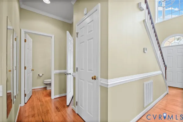 a view of a hallway with wooden floor and staircase