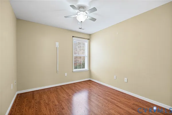 an empty room with a window and a ceiling fan