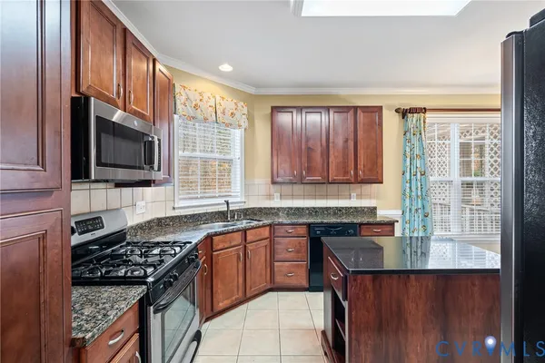 a kitchen with granite countertop a sink stove top oven and cabinets