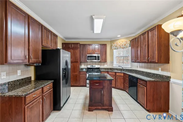 a kitchen with stainless steel appliances granite countertop wooden cabinets a stove top oven a sink and dishwasher