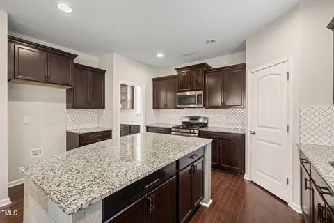 a kitchen with stainless steel appliances granite countertop a sink stove microwave and refrigerator