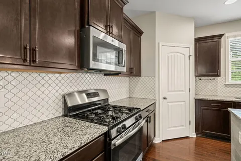 a kitchen with granite countertop cabinets and steel stainless steel appliances