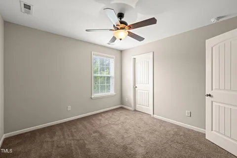 a view of an empty room and a ceiling fan