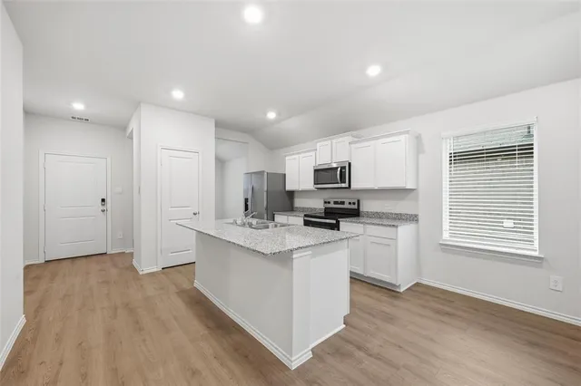a kitchen with stainless steel appliances a refrigerator sink and microwave