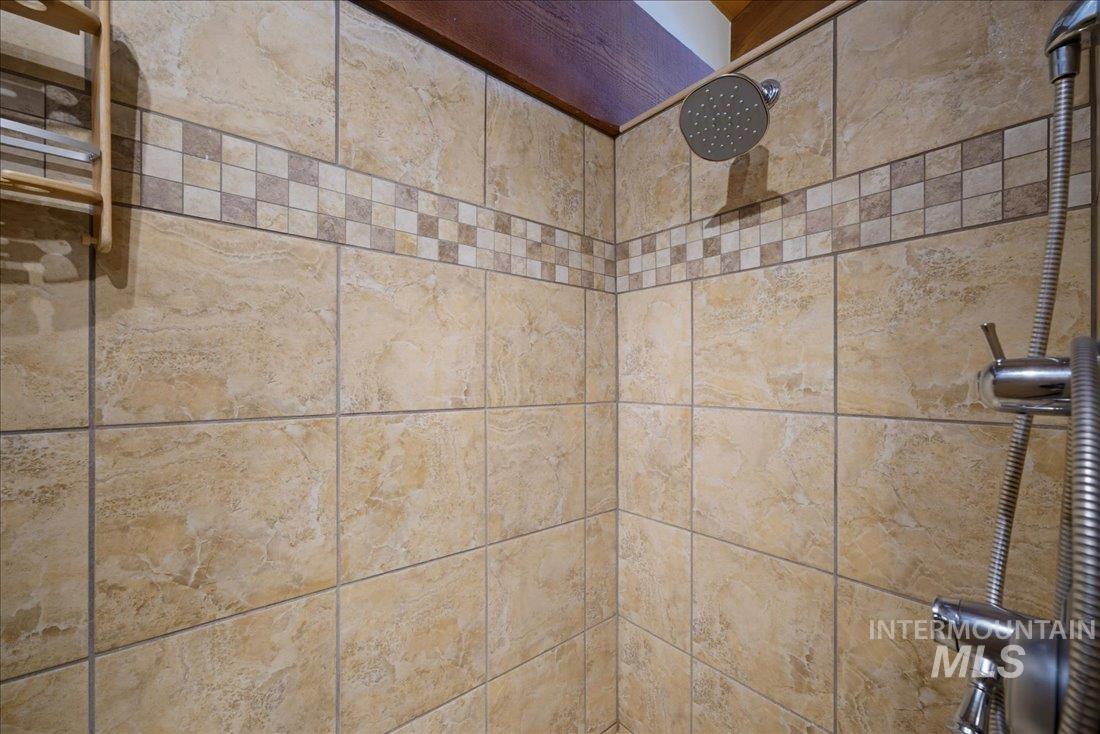 3800 Warren Wagon Road McCall, ID 83638 - Photo 23 of 50 Shower featuring neutral-toned tile work with a decorative mosaic accent band