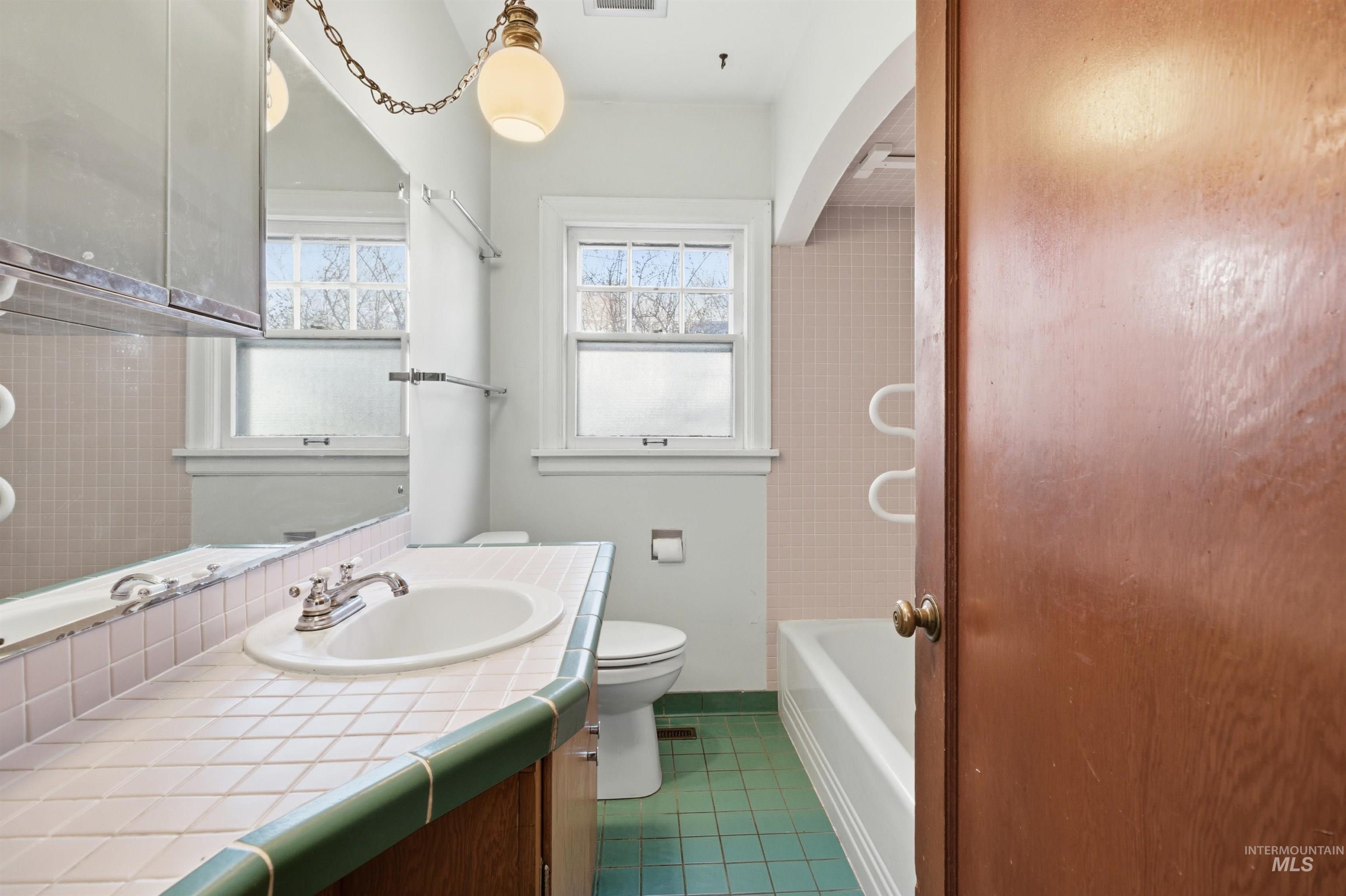 1117 East 6th Street Moscow, ID 83843 - Photo 25 of 46 Full bathroom featuring vanity and dark tile patterned flooring