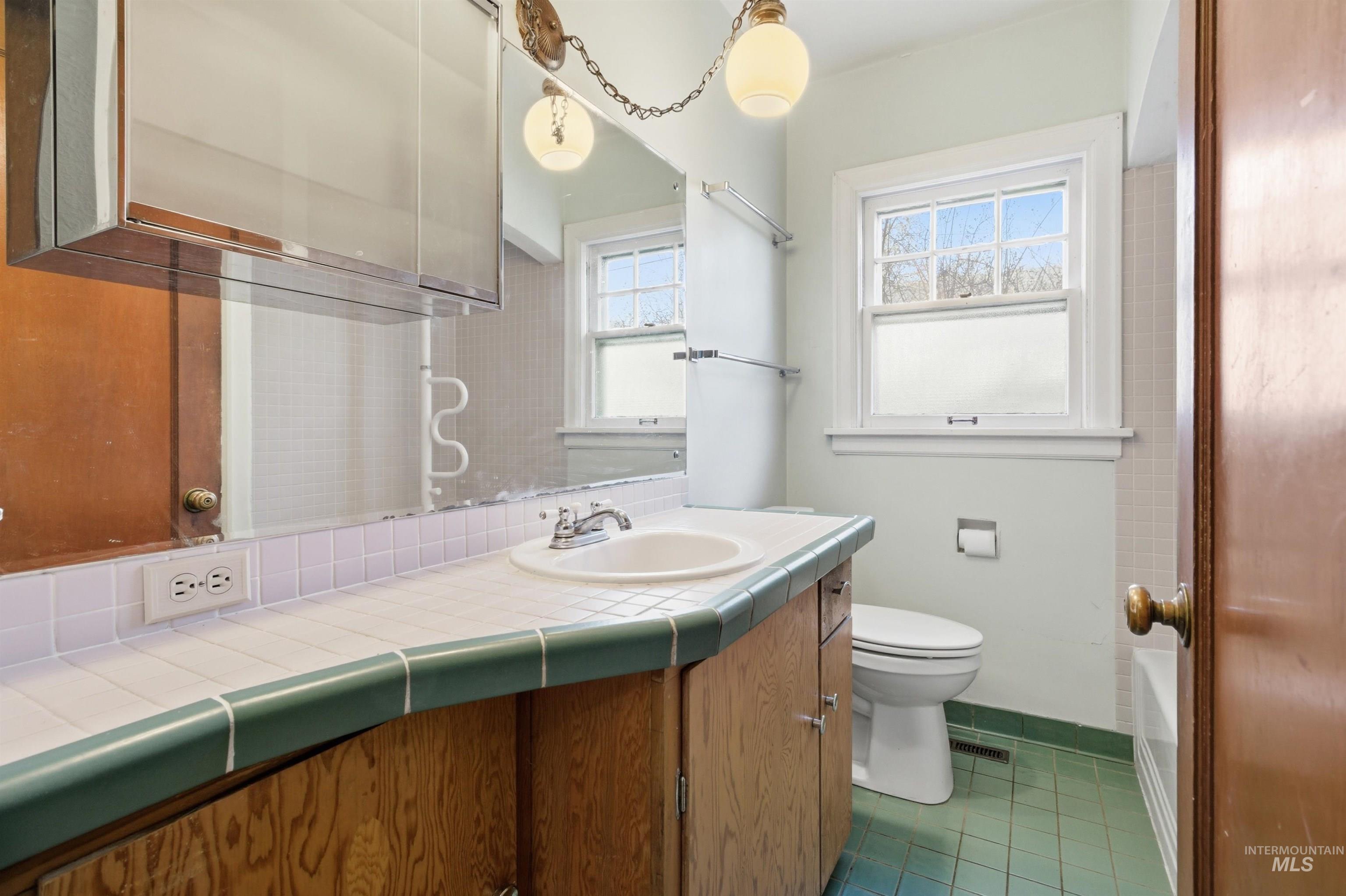 1117 East 6th Street Moscow, ID 83843 - Photo 26 of 46 Full bathroom featuring vanity, dark tile patterned floors, and healthy amount of natural light