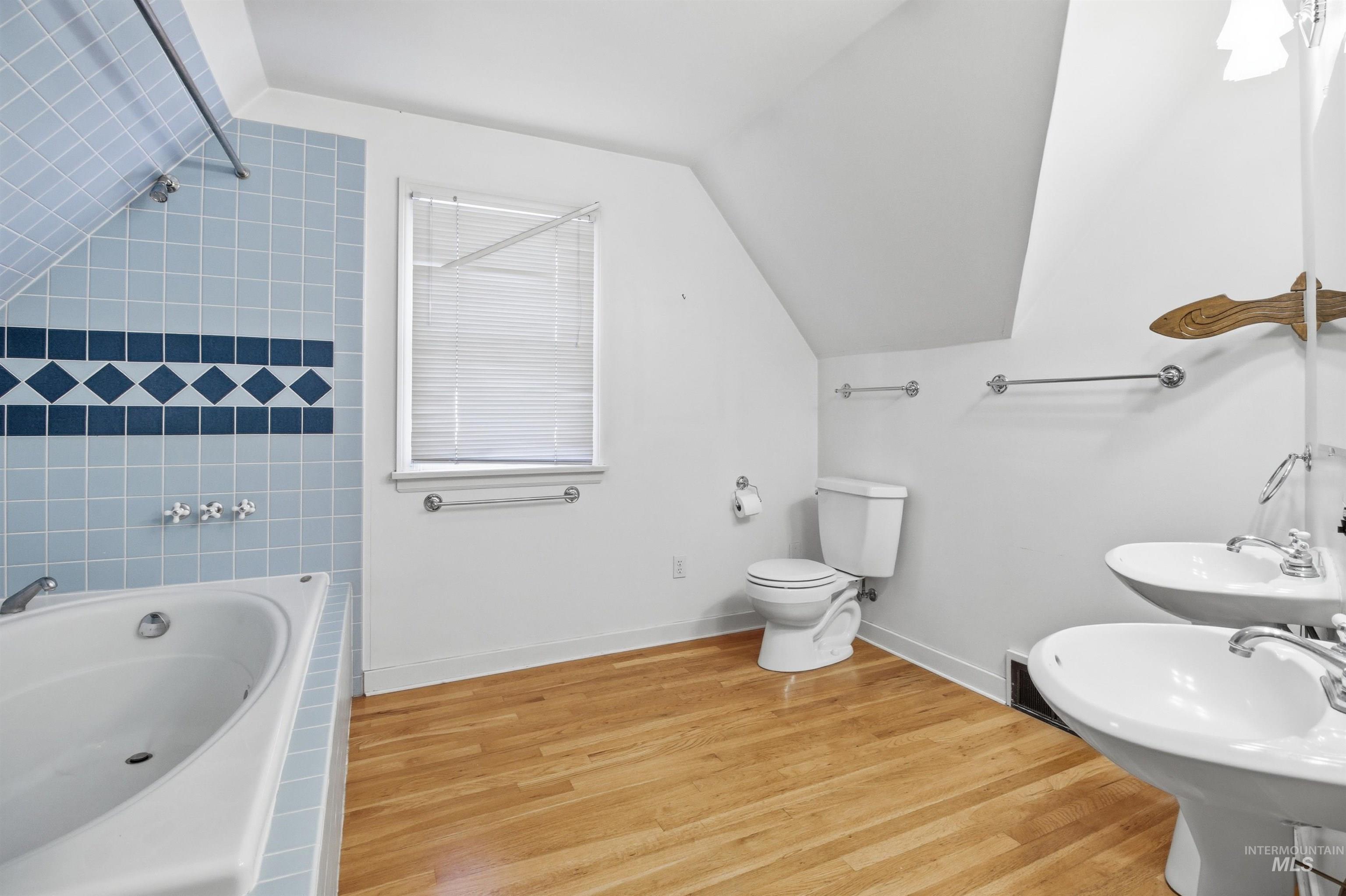 1117 East 6th Street Moscow, ID 83843 - Photo 36 of 46 Full bathroom with light wood-style floors, vaulted ceiling, and washtub / shower combination