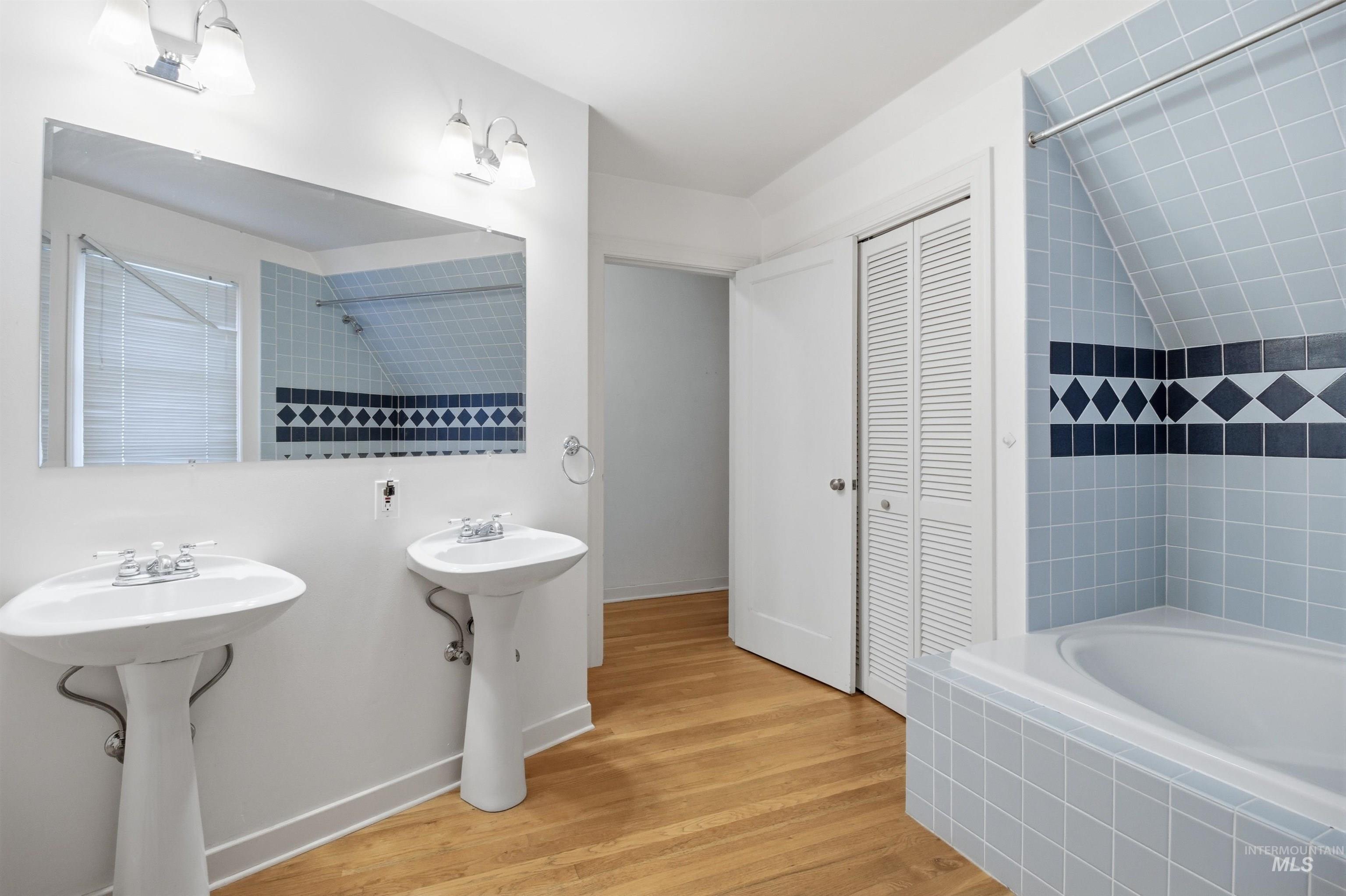 1117 East 6th Street Moscow, ID 83843 - Photo 38 of 46 Bathroom featuring light wood-style floors, tiled shower / bath, a closet, and two sinks
