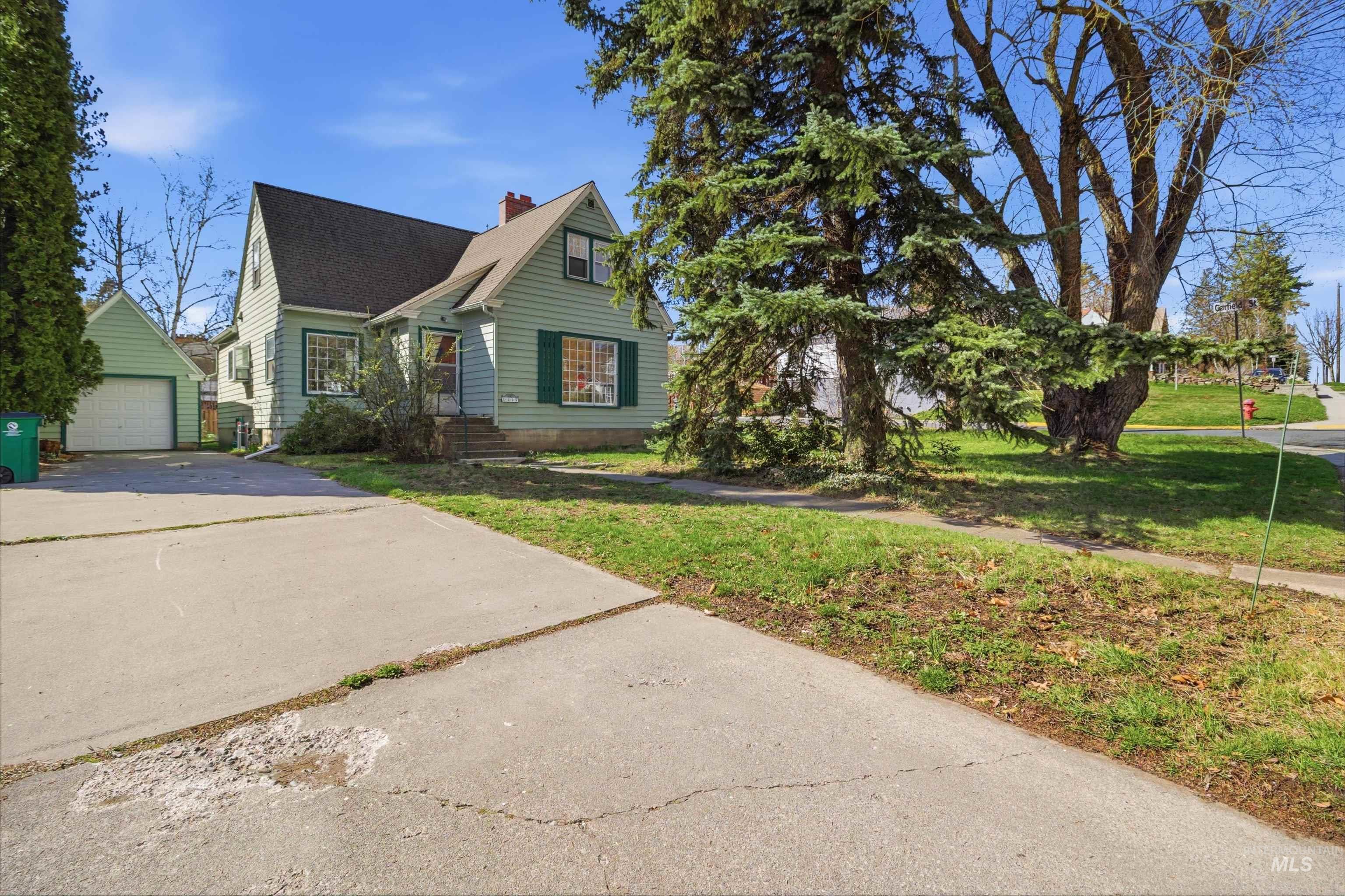 1117 East 6th Street Moscow, ID 83843 - Photo 4 of 46 View of front of house with an outbuilding, a chimney, a front lawn, and a garage