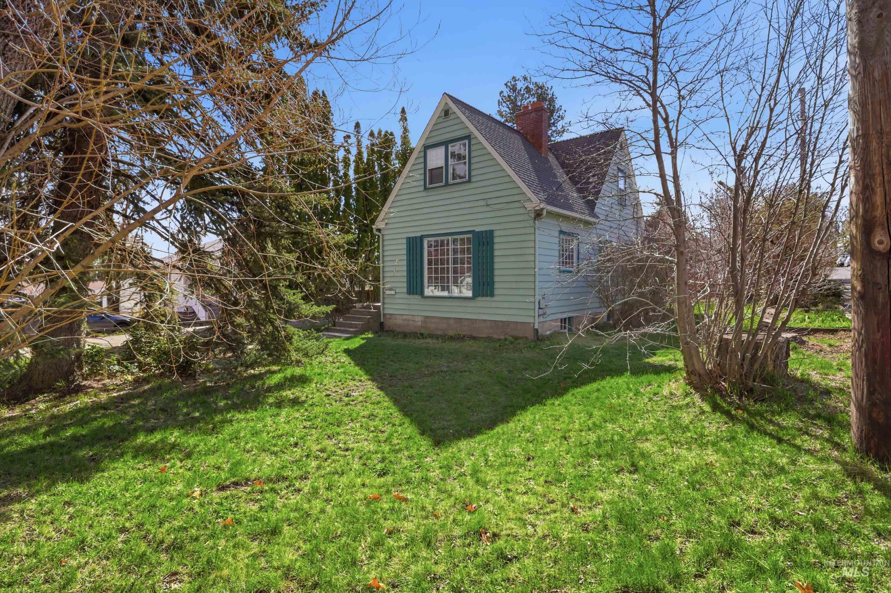 1117 East 6th Street Moscow, ID 83843 - Photo 10 of 46 View of property exterior featuring a chimney, a yard, and roof with shingles