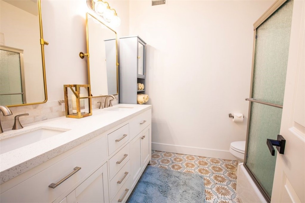 32052 Via Alicia San Juan Capistrano, CA 92675 - Photo 27 of 39 a bathroom with a double vanity sink and mirror