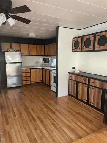 a kitchen with stainless steel appliances wooden floors and wooden cabinets