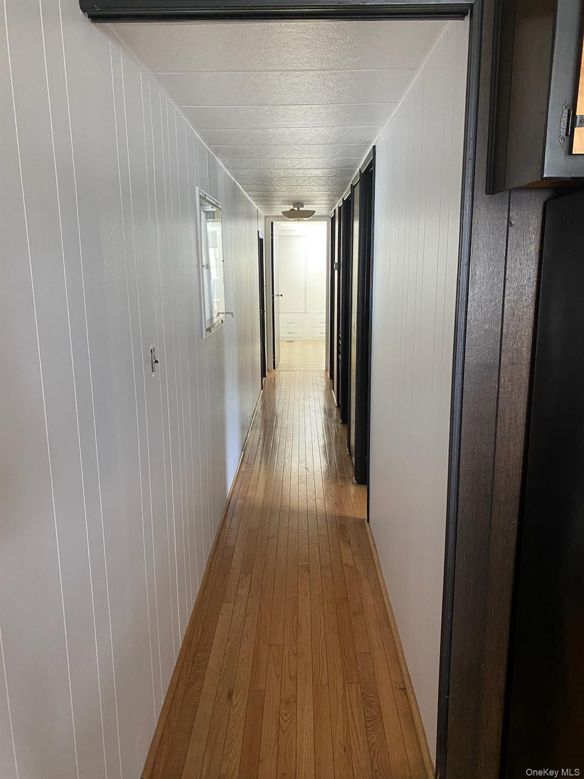 1661 Old Country Road, Unit 308 Riverhead, NY 11901 - Photo 5 of 10 a view of hallway with wooden floor