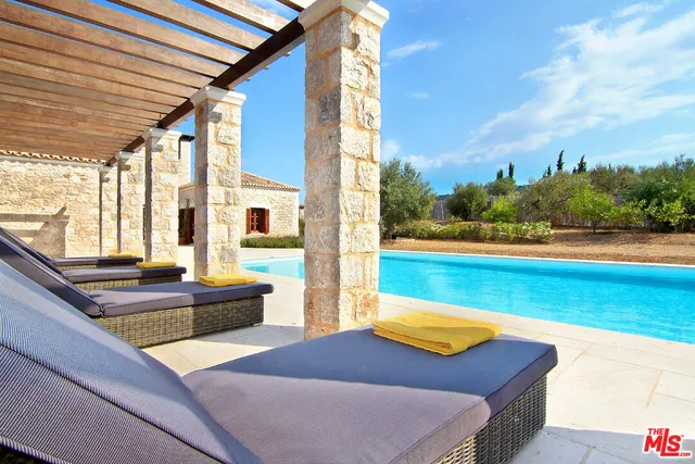 a view of a backyard with chair and table in the patio