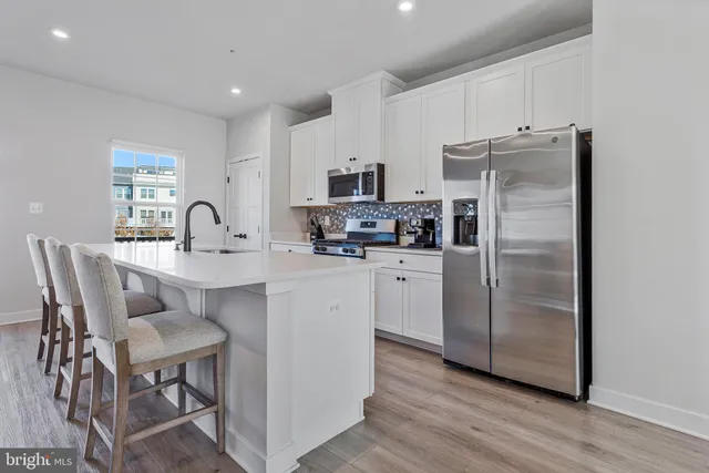 a kitchen with stainless steel appliances a dining table and chairs